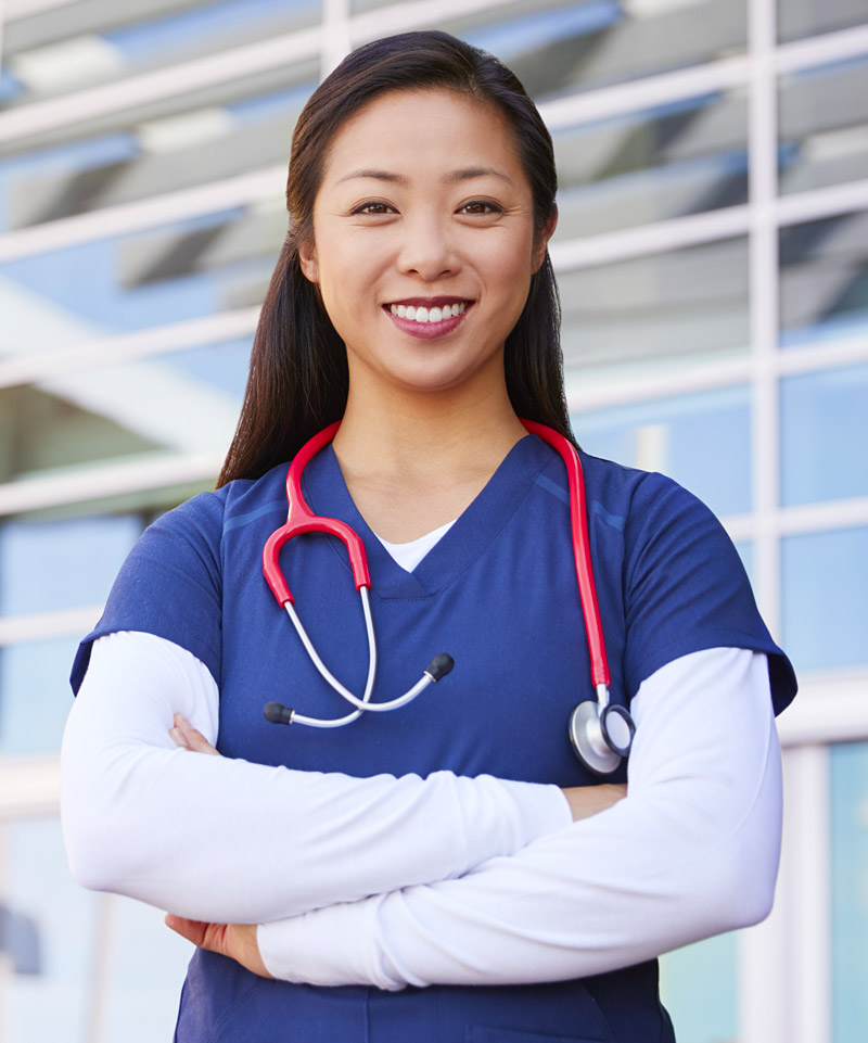 Healthcare professional in front of hospital building